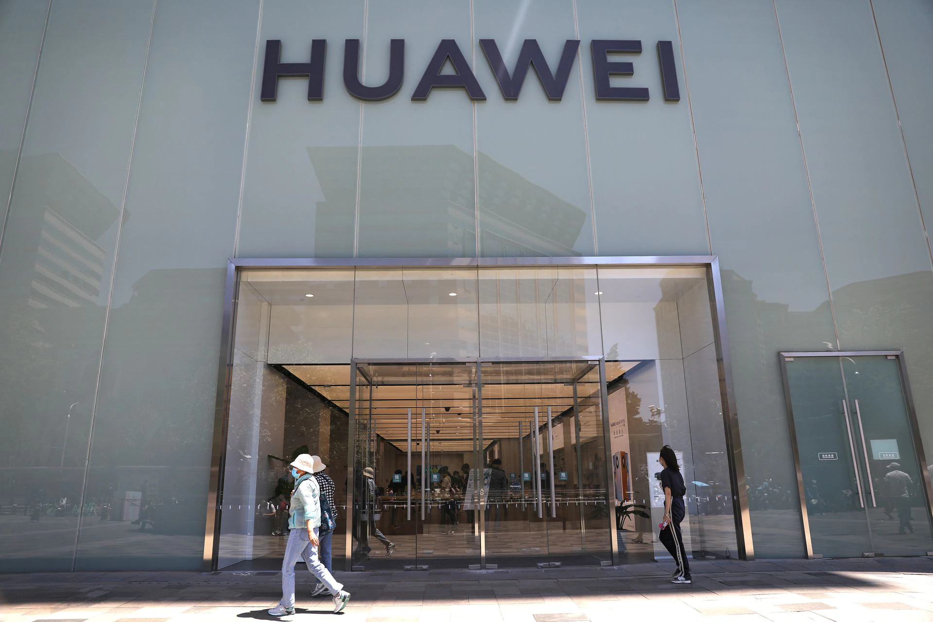 Gyalogosok egy pekingi Huawei kereskedés elõtt (Kép Reuters/Tingshu Wang)